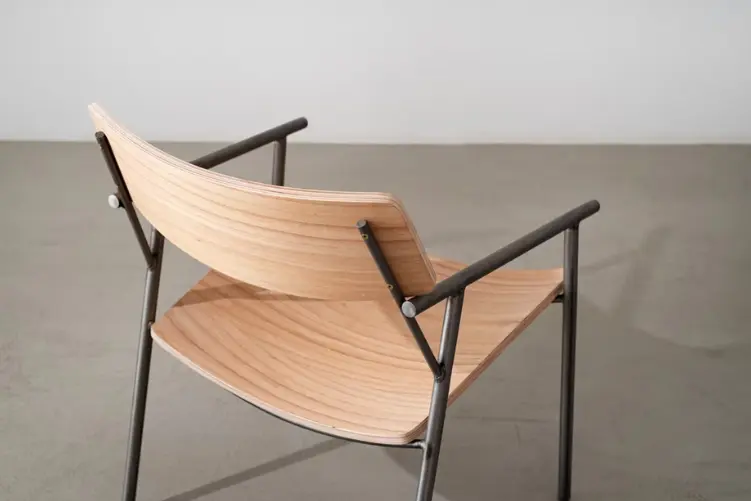 Detalhe posterior de poltrona em madeira multilaminada e metal