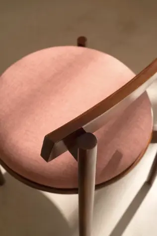 Detalhe superior de poltrona estofada em rosa